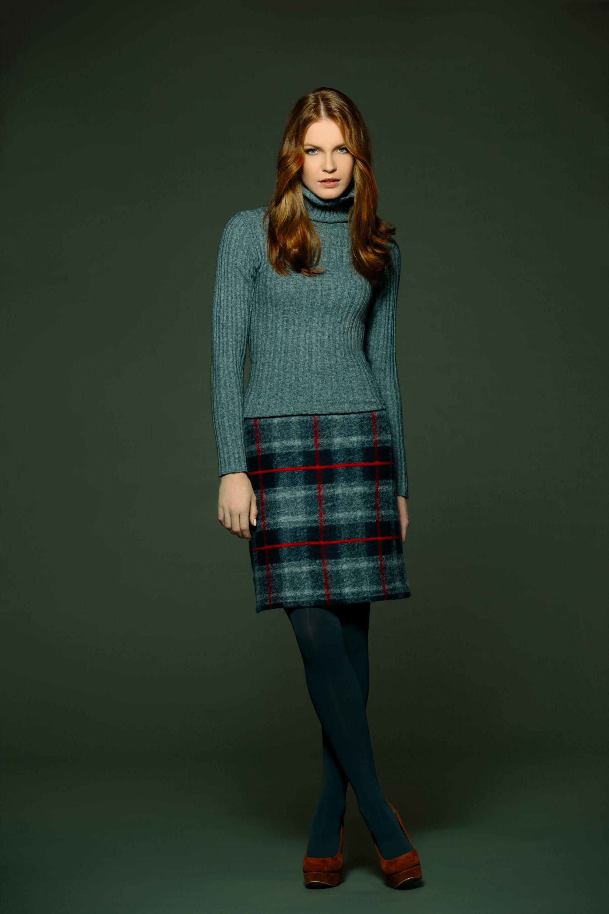 Model mit rotblonden Wellen in grauem Pullover und Karorock, Hirsch Rock